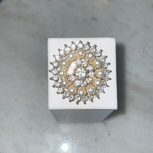 Round brooch with rhinestones and faux pearls; 1.5 inches in diameter